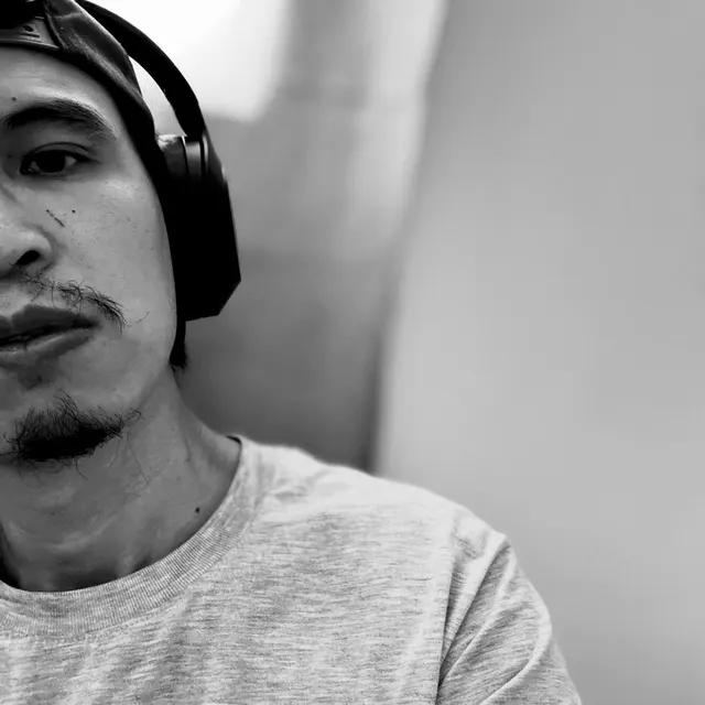 Black-and-white portrait of Lawrence Gimenez wearing headphones